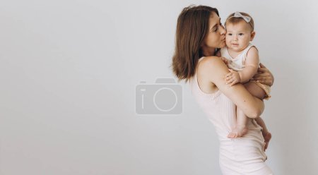 Foto de Feliz madre joven con su adorable niña sobre fondo blanco - Imagen libre de derechos