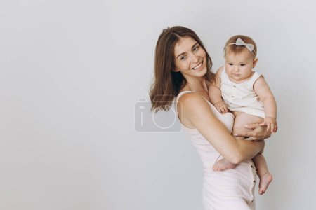 Photo for Happy young mother with her adorable baby girl on white background - Royalty Free Image