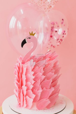 Photo for Cute pink cake with flamingo on paper pink and balloons background in studio - Royalty Free Image