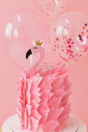 Photo for Cute pink cake with flamingo on paper pink and balloons background in studio - Royalty Free Image