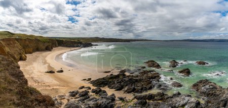 Téléchargez les photos : Une vue sur la plage de Gwithian avec de l'eau tropicale turquoise et la côte de Cornouailles derrière - en image libre de droit