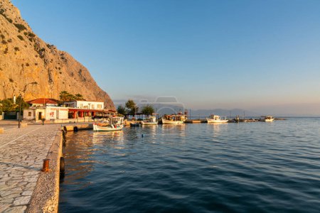 Foto de La pequeña aldea de pescadores de Kryoneri en el Golfo de Corinto con la montaña Vasarova al atardecer - Imagen libre de derechos