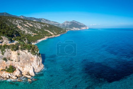 Téléchargez les photos : Vue aérienne de la côte montagneuse accidentée près de Cala Gonone avec de l'eau turquoise et de petites plages de sable blanc - en image libre de droit