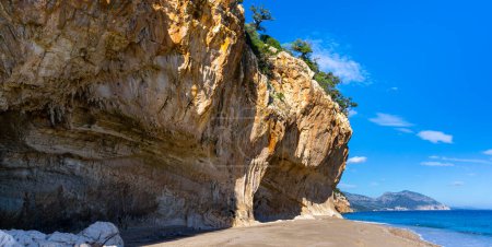 Foto de Los acantilados colgantes y la playa de arena en Cala Luna en la costa este de Cerdeña - Imagen libre de derechos