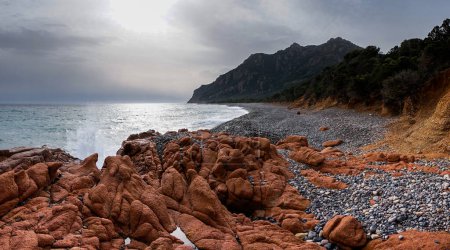 Téléchargez les photos : Côte sauvage accidentée en Sardaigne avec des vagues s'écrasant sur des rochers de granit rouge au premier plan - en image libre de droit