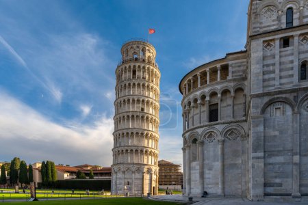 Photo for Pisa, Italy - 30 November, 2022: the Leaning Tower of Pisa and the Cathedral in warm evening light with a sunburst - Royalty Free Image