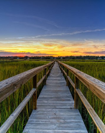 Langes hölzernes Dock an der Bucht von Pawleys Island in South Carolina in warmem goldenem Licht bei Sonnenuntergang