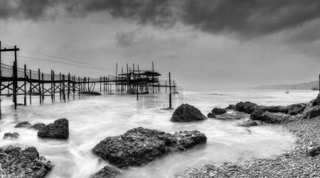 Photo for A black-and-white view of the Trabocco Cungarelle pile dwelling on an overcast an rainy day on the Costa dei Trabocchi in Italy - Royalty Free Image