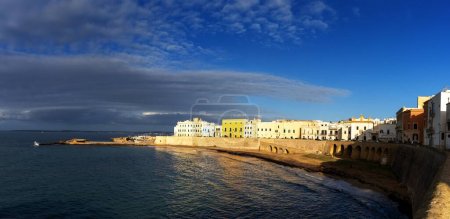 Photo for Gallipoli, Italy - 29 November, 2023: view of the waterfront of the historic old town of Gallipoli in warm evening light - Royalty Free Image
