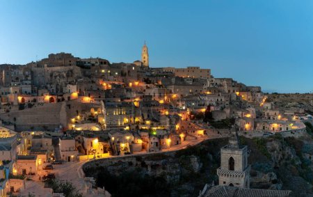 Foto de Matera, Italia - 26 noviembre, 2023: vista del casco antiguo de Matera después de la puesta del sol con las luces que vienen enMatera, Italia - 26 noviembre, 2023: - Imagen libre de derechos