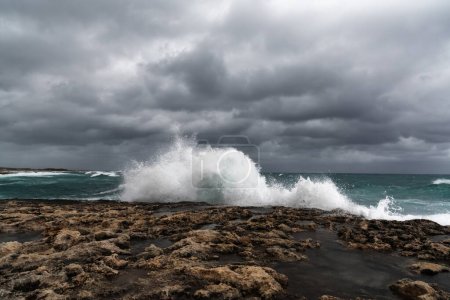 Foto de Olas de tormenta que se estrellan en las costas rocosas de la playa de Pembroke en Malta bajo un cielo nublado - Imagen libre de derechos