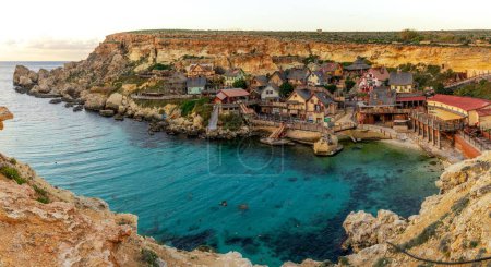 Foto de Mellieha, Malta - 20 de diciembre de 2023 vista de la idílica Bahía de Ancla y el parque de atracciones Popeye Village en Malta - Imagen libre de derechos