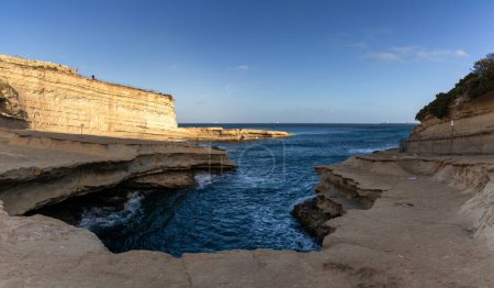 Foto de Cálida luz de la tarde sobre el punto de referencia de la piscina de San Pedro en Delimara Point en Malta - Imagen libre de derechos