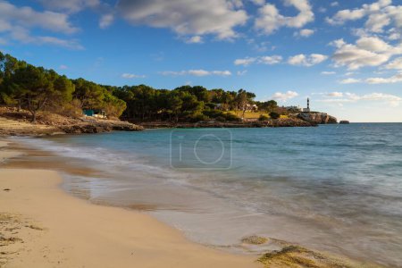 A view of the Arenal dets Ases beach and the Portocolom Lighthouse in the background