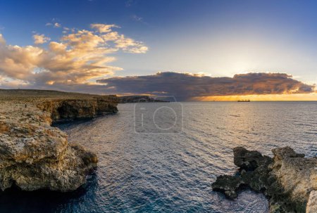 A sunset seascape in Malta with the Popeye Cliffs and a view of the ocean at Anchor Bay