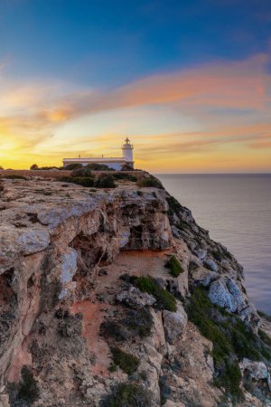 A vertical view of the Cap Blanc lighthouse in southern Mallorca at sunrise