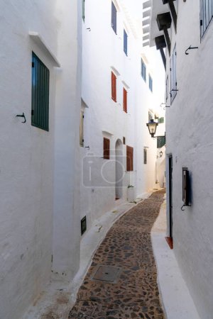 Binibeca Vell, Spain - 24 January, 2024: narrow alley leading through a maze of whitewashed buildings in the village center of Binibeca Vell