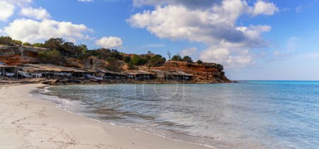 Viele alte Fischerhütten und Bootsgaragen am Strand und in der Bucht von Cala Saona auf Formentera