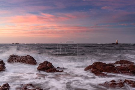 Vista de larga exposición de la costa de la isla de Sant 'Antioco y de la Mangiabarche Lighthosue al amanecer en Cerdeña