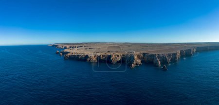 A drone panorama view of the Punta Nati lighthouse and coastal cliffs in northwestern Menorca