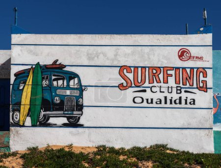 Téléchargez les photos : Oualidia, Maroc - 27 mars 2024 : vue rapprochée du bâtiment Oualidia Surfing Club sur la plage dans le nord-ouest du Maroc - en image libre de droit