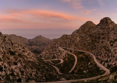 Farbenfroher Sonnenaufgang im Tramuntana-Gebirge von Mallorca mit Blick auf die markante Schlangenstraße, die hinunter nach Sa Calobra führt