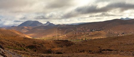 A panorama landscape view of the Altas mountains in Morocco with small villages dotting the hillsides