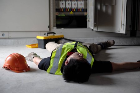 Photo for Accident in work of electrician people or Maintenance worker in the control room of factory. Lying unconscious on the floor in power electrical control room. - Royalty Free Image
