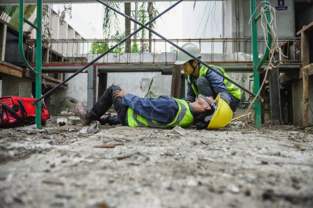Photo for First aid support accident at work of builder worker in construction site. Accident falls from the scaffolding on floor, Foreman help employee accident with first aid bag - Royalty Free Image