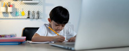 Téléchargez les photos : Asian Kid Boy se concentre sur les devoirs et l'apprentissage seul dans la chambre à la maison, Serious Asian Kid se concentre sur les devoirs, les études et le succès, les devoirs et l'éducation des enfants asiatiques Concept en taille de bannière. - en image libre de droit