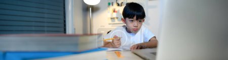 Téléchargez les photos : Asian Kid Boy se concentre sur les devoirs et l'apprentissage seul dans la chambre à la maison, Serious Asian Kid se concentre sur les devoirs, les études et le succès, les devoirs et l'éducation des enfants asiatiques Concept en taille de bannière. - en image libre de droit
