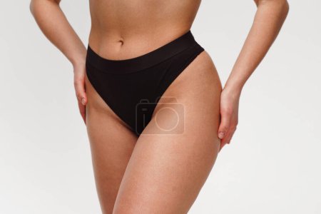 Photo for A woman with a beautiful feminine figure in black lingerie with overweight, cellulite and stretch marks. Obesity, hormones and health. Isolated ona white background. - Royalty Free Image