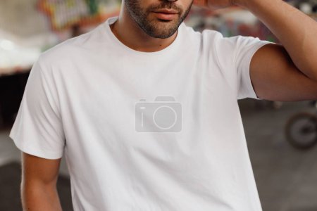 Téléchargez les photos : Portrait d'un beau jeune homme barbu près d'un mur de graffiti - en image libre de droit