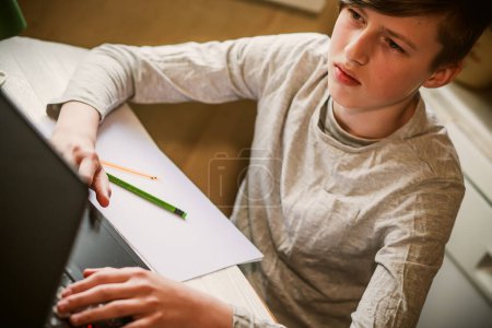 Photo for A teenager looks at a laptop screen. Remote learning. Back to school. Classes for children online during the war in Ukraine - Royalty Free Image