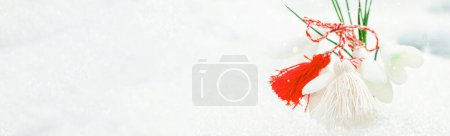 Photo for White and red cord martisor. Martenitsa in the snow in the spring. Symbols of spring. Baba Marta holiday. Tradition in Bulgaria. Baba Marta Day. - Royalty Free Image