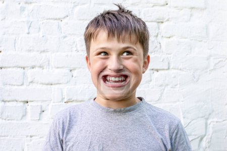 Photo for Grinned at child. boy smiling at 32 teeth. rocky over-the-erring child. Funny face in a teenager. Children's emotions - Royalty Free Image