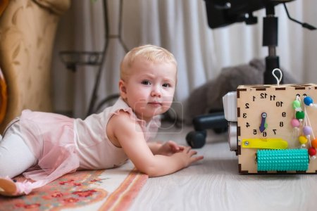 Foto de Montessori Juguete sensorial para habilidades motoras finas. Bebé aprende números en un juego de puzzle mostrando una pequeña pluma en el reloj - Imagen libre de derechos