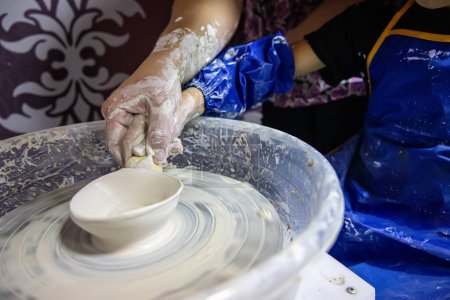 Téléchargez les photos : Un petit enfant avec un professeur tout en apprenant les compétences de la poterie - en image libre de droit