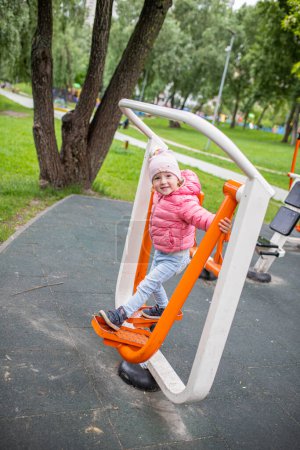 Photo for WORKOUT street. Baby on the Street simulator FEET BREEDING in a city park. Easy-to-use cardiovascular fitness equipment. Prevention of cardiovascular diseases. - Royalty Free Image