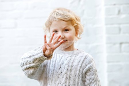 Photo for Childs playful demeanor continues with a cheerful display of four tiny fingers. - Royalty Free Image