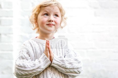 Photo for Serene expression as the child clasps their hands in quiet prayer. - Royalty Free Image