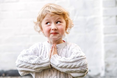 Photo for Purity of a childs faith shines through as they offer a heartfelt prayer with folded hands. - Royalty Free Image
