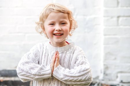 Photo for Innocence and faith captured as the little one prays with folded hands. - Royalty Free Image