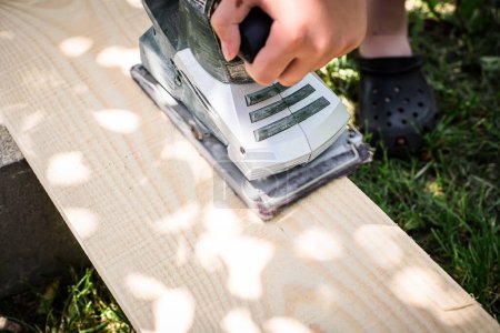 Photo for Electric Planer in Action. Professional carpenter shaping wood with an electric hand planer - Royalty Free Image