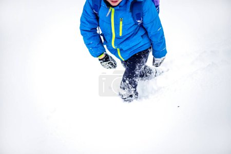 Téléchargez les photos : Petit garçon s'amusant sur la neige dans le parc d'hiver. Activités hivernales pour les enfants - en image libre de droit