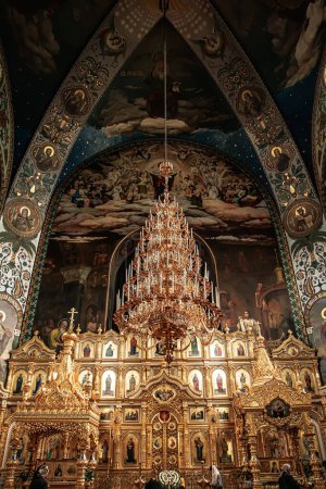 Photo for Interior Saint Nicholas Cathedral of the Holy Intercession Convent for Women in Kyiv Iconostasis with Royal Doors with Chandelier with Candles, Candelabrum, Polycandelon. - Royalty Free Image
