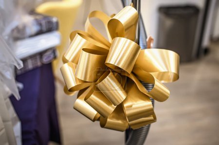 Photo for Close up of a golden bow on a swing in a wedding salon. - Royalty Free Image