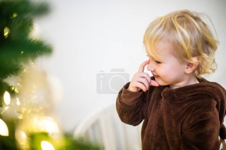 Téléchargez les photos : Une petite fille en costume de renne de carnaval pense à quel jouet décorer un arbre de Noël avec - en image libre de droit