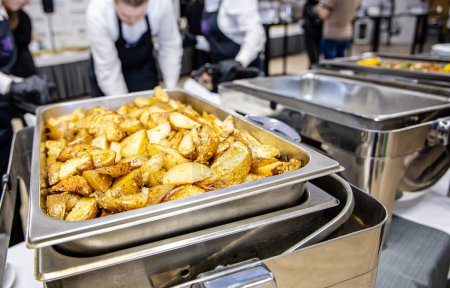Photo for Catering buffet food indoor in hotel restaurant, catering service concept. Fried potatoes in a stainless steel tray in a restaurant or cafe - Royalty Free Image