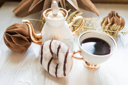 Foto de Taza de café y donut de chocolate sobre fondo de madera blanca. Decoraciones de Navidad de papel Kraft hecho a mano - Imagen libre de derechos